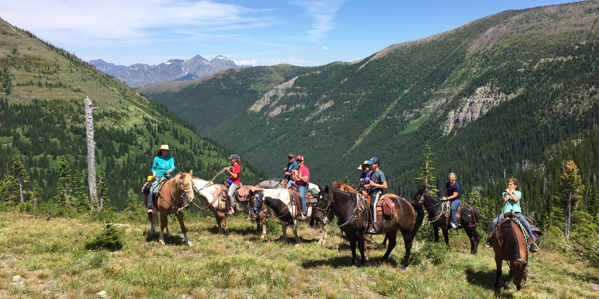 horses and riders resting atop mountain